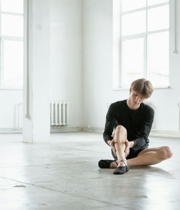Man performing a controlled bodyweight exercise in a bright studio.